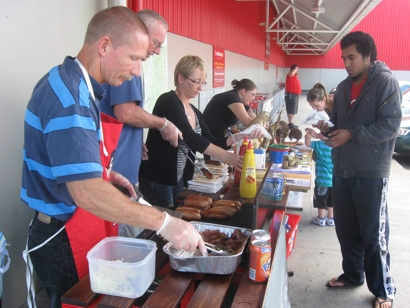 Trust members fundraising at the Petone Warehouse by running a Sausage Sizzle