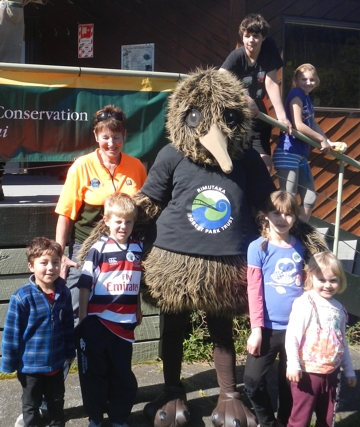 Rimu the Kiwi surrounded by children at the Planting Day for families at the Catchpool during Conservation Week 2013