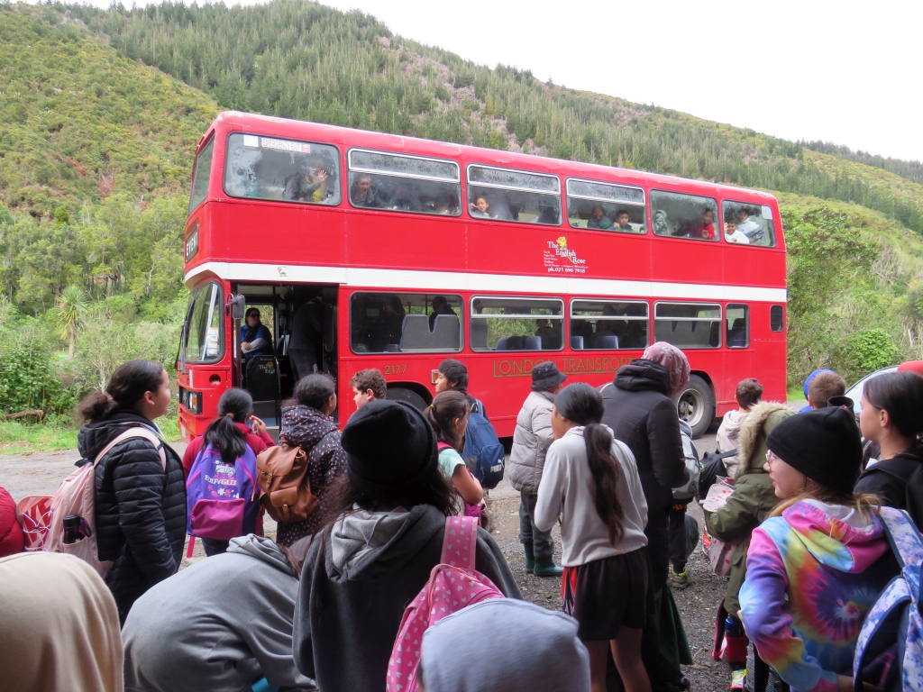 Double-deck London bus delivering school children to their Catchpool Valley restoration site for tree planting